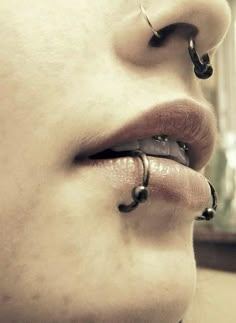 a woman with piercings on her nose and nose ring in front of her face