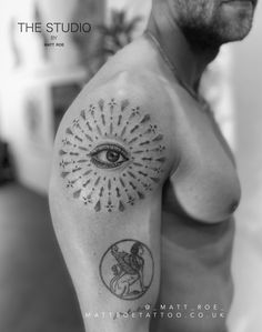 a man with an eye tattoo on his arm