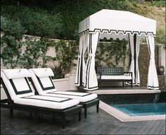 a gazebo sitting next to a swimming pool with chaise lounges on it