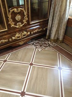 an ornately decorated floor in a room with wooden furniture and curtains on the window sill