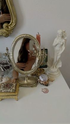 a woman's reflection in a mirror on top of a table next to other items