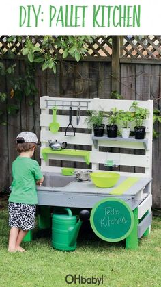 a little boy playing in the backyard with an outdoor kitchen made out of pallets