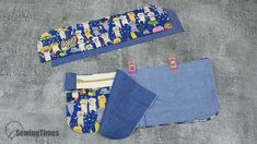 two pieces of blue fabric with cartoon characters on them, one has a zippered pouch and the other has an inner pocket