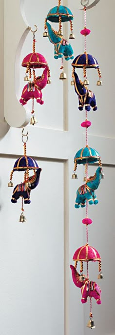 an assortment of colorful bells hanging from a wall