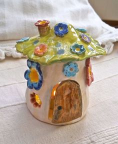 a small ceramic house with flowers on it