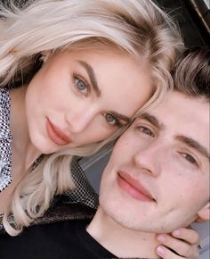 a man and woman are posing for a photo in the back seat of a car