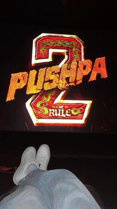 a person laying on the ground in front of a sign that says pushba 2