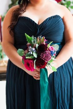 a woman in a black dress holding a bouquet