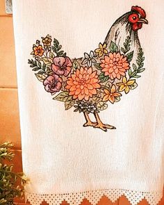 a white towel with a rooster and flowers on it