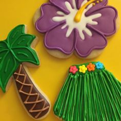 some decorated cookies are sitting on a yellow tablecloth and there is a palm tree