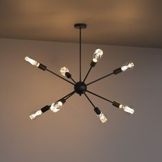 a chandelier with eight lights hanging from it's ceiling in a room