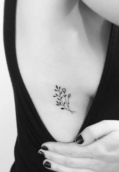 a woman's chest with a small flower tattoo on it