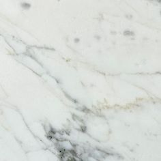 a white marble textured surface with black dots on the top and bottom, as seen from above