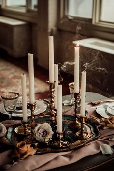 a table topped with lots of candles and plates