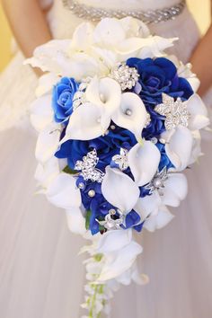 a bridal bouquet with blue and white flowers on the bride's wedding day