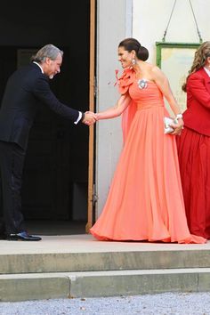 a man and woman in formal wear shaking hands