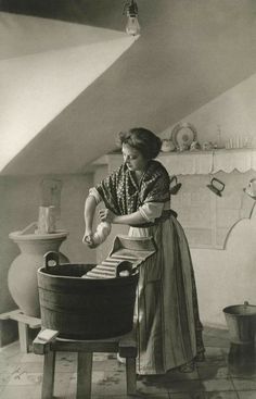 an old photo of a woman ironing clothes