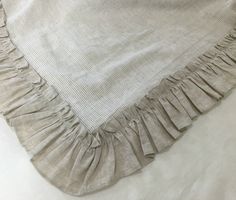 a blanket with ruffled edges laying on top of a bed