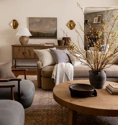 a living room with couches, chairs and a coffee table in front of a painting