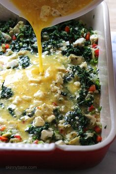 a casserole dish with cheese being poured into it and broccoli in the background