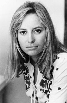 a black and white photo of a woman with long hair wearing a flowered shirt