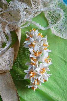 some white flowers are sitting on a green cloth