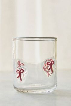 a clear glass with red bows and hearts on the inside is sitting on a table