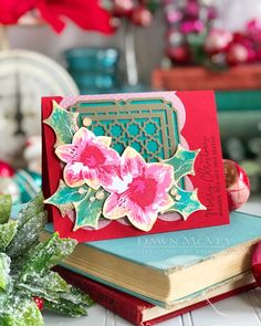 a close up of a book with flowers on it next to a potted plant