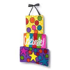 a colorful wooden block with the word celebrate on it and stars around it, hanging from a string