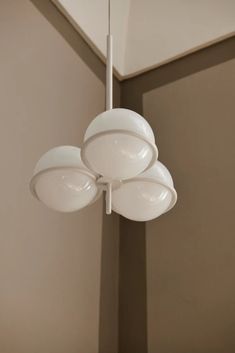 three white lights hanging from the ceiling in a room with beige walls and flooring