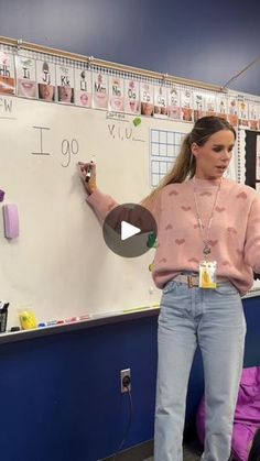 a woman standing in front of a white board