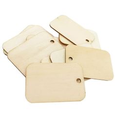 four wooden tags with holes on them, all in different shapes and sizes are placed next to each other