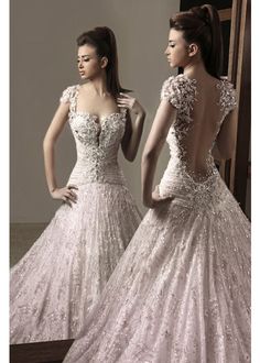 two women in wedding dresses looking at each other with their backs turned to the camera