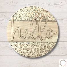 a wooden sign with the word hello painted on it's side and an animal print pattern