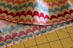 two pieces of fabric sitting on top of a cutting board