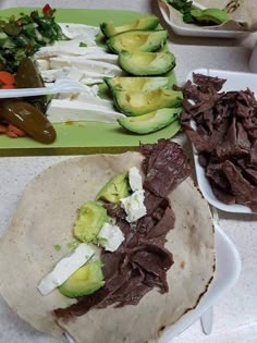 there are many different types of food on the table together, including tortillas and avocado