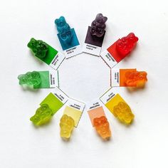 a group of gummy bears sitting in a circle on top of a white surface