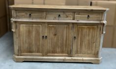 a large wooden cabinet with drawers and knobs on the doors is shown in front of cardboard boxes