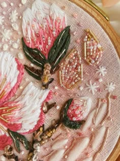 a close up of a piece of art with beads and flowers on the embroidery board