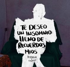 a man sitting on top of a chair in front of a sign that says, te deso un insomno llenodo de regerdos mios