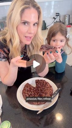 a woman and her daughter are eating chocolate desserts on the kitchen counter top together