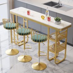 three stools and a table in a kitchen with marble counter tops, gold metal barstools and green cushions