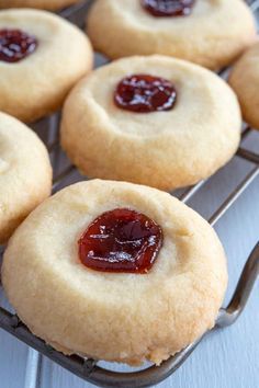 several cookies with jelly on top sit on a cooling rack, ready to be eaten