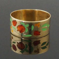 two rings with flowers painted on them sitting next to each other in front of a gray background