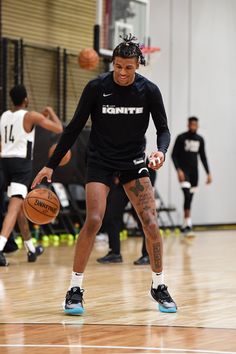 a basketball player dribbles the ball on his feet while playing with other players