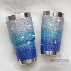 two blue and silver glitter tumblers sitting next to each other