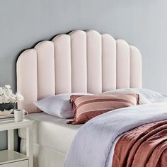 a pink headboard on a white bed in a bedroom