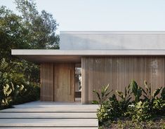 a modern house with wooden slats on the front and side walls, surrounded by greenery