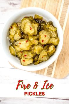 a white bowl filled with pickles on top of a wooden cutting board