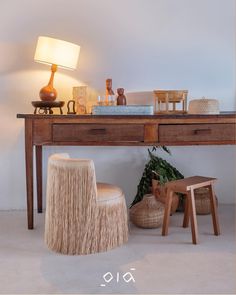 a wooden table with two stools and a lamp